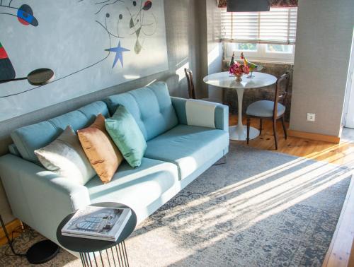 波尔图Apartment by the Sea的客厅配有一张蓝色的沙发,配有一张桌子