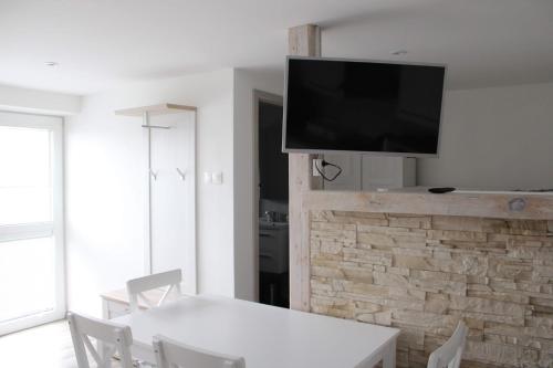 Spišské TomášovceUbytovanie Ľaľa的客厅配有白色桌子和墙上的电视