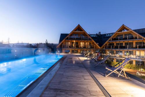 扎科帕内APARTHOTEL ROYAL RESORT SPA Zakopane的一座大型游泳池,其建筑背景为: