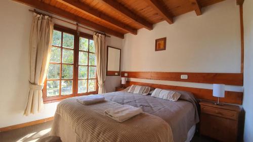 拉安戈斯图拉镇Cabañas & Aparts Lancuyen, Villa de Montaña的一间卧室配有一张床,上面有两条毛巾