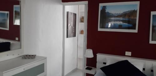 萨迪纳Faro de sardina Apartment的卧室配有白色的床和红色的墙壁