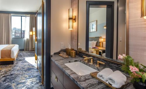 丹佛Clayton Hotel & Members Club的一间带水槽和大镜子的浴室