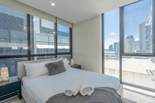 墨尔本Melbourne City Apartments - Teri的卧室设有白色的床和大窗户