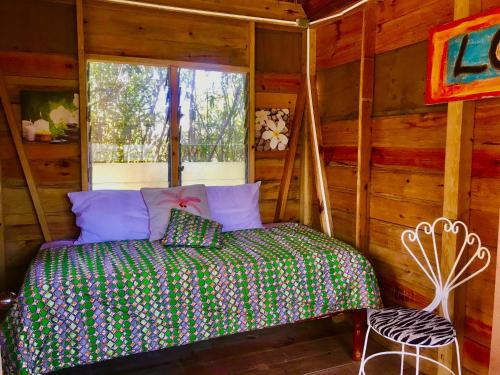 特雷热比奇Moringa Ingadi的一间位于小屋内的卧室,配有一张床和一个窗户