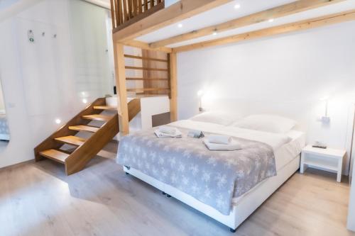 索普隆尔哈德潘兹奥酒店的一间卧室设有一张大床和木制楼梯。