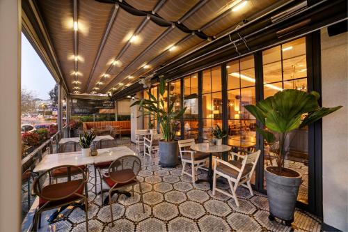 伊斯坦布尔39 Kalamış Marina Hotel & Restaurant的一个带桌椅和植物的餐厅庭院