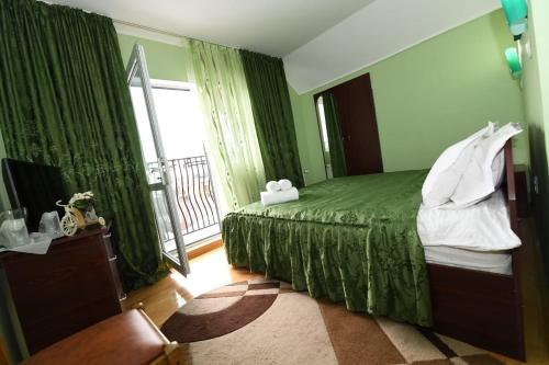 坎皮纳尼娜别墅酒店的一间卧室设有一张绿色的床和一个窗户。