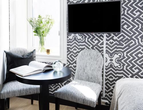 奥斯陆Frogner House - Bygdøy Allé的客厅配有桌子、两把椅子和电视