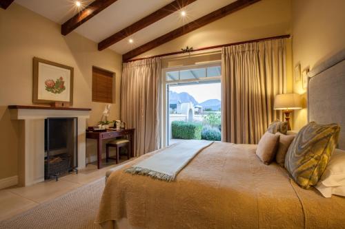弗朗斯胡克卡布里尔乡村酒店的一间卧室设有一张带壁炉和窗户的床。