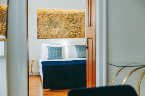 里斯本54 São Paulo - Exclusive Apartment Hotel的一间卧室配有一张带蓝色和白色枕头的床