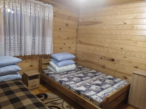 斯维季亚济Лукі的一间卧室设有木墙和一张带枕头的床。