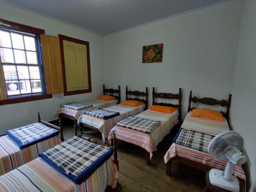 迪亚曼蒂纳Pousada Dona Dazinha的带四张床和窗户的客房