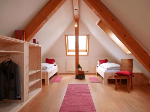 欣特察尔滕Oskar's Chalets的阁楼间 - 带两张床和窗户