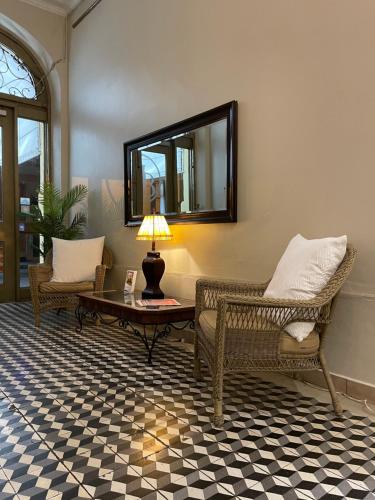 庞塞拜尔吉卡精品酒店的客厅配有两把椅子、一张桌子和镜子