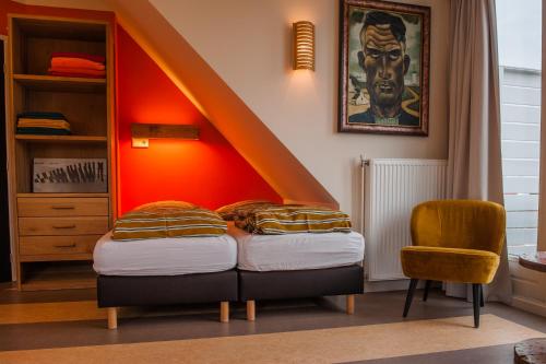 韦斯特卡佩勒海滨一室公寓的一间卧室配有一张橙色墙壁的床