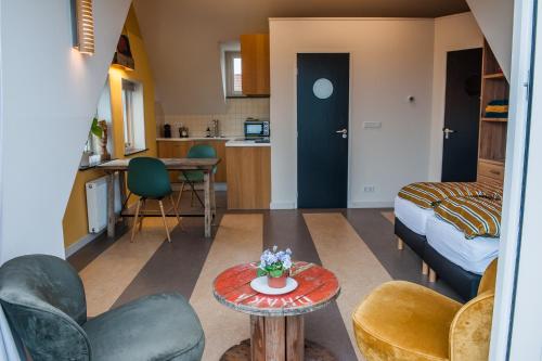 韦斯特卡佩勒海滨一室公寓的一个小客厅,配有一张床和一张桌子