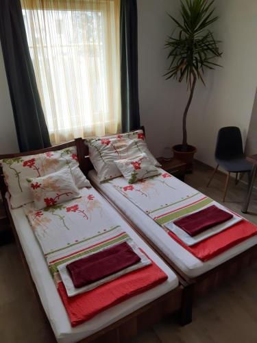 德布勒森M47 Vendégház-Airport的卧室内的两张床、毛巾和枕头