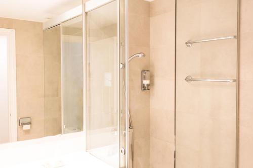 休达德亚Sagitario Petit Ciutadella的浴室里设有玻璃门淋浴