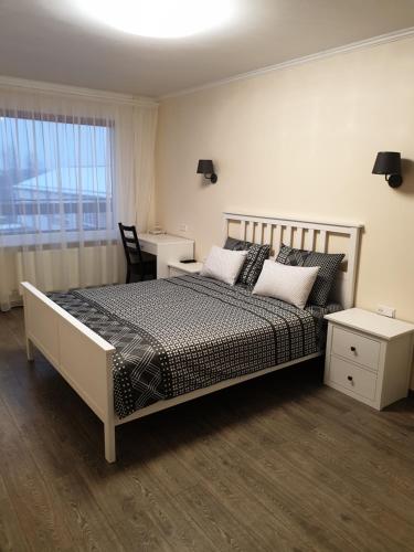 古尔贝内Swan City Apartment的一间卧室配有一张床、一张书桌和一个窗户。
