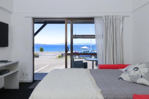 陶波Gables Lakefront Resort的一间卧室配有一张床,享有海景