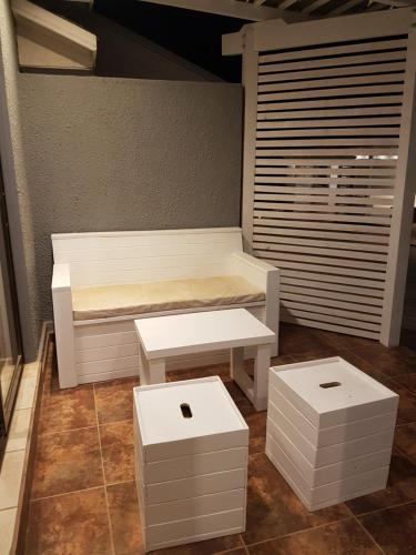 皮奇勒姆卡瓦尼亚斯恩托斯德尔玛旅舍的房间里的一张白色长凳和两张凳子