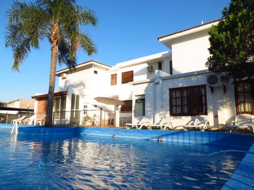 维拉卡洛斯帕兹Casa Piedra Hotel的棕榈树屋前的游泳池