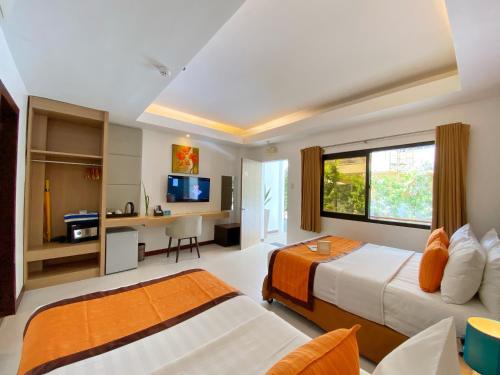 长滩岛乔伊海滩度假村的酒店客房配有两张床和一张书桌