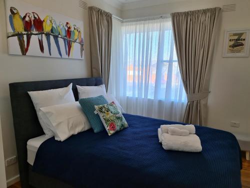 HardenHarden Golfers Rest Accommodation的一间卧室配有一张蓝色的床,上面有毛巾