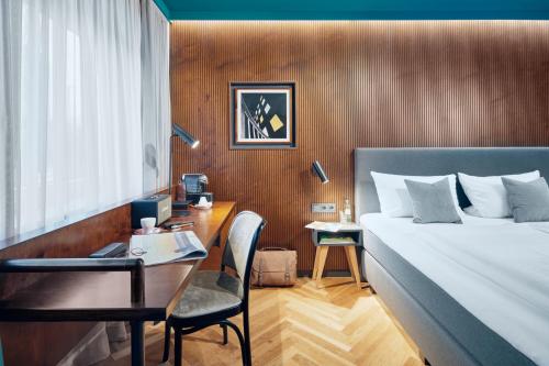 波鸿图霍尔斯基酒店的一间卧室配有一张床和一张桌子及椅子
