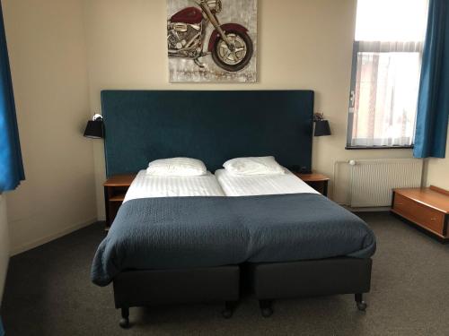 芬洛威廉明娜酒店的一间卧室配有一张蓝色床头板的床