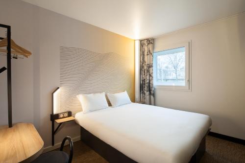 马恩河畔的尚格尼B&B HOTEL Champigny-sur-Marne的卧室设有一张白色大床和一扇窗户。