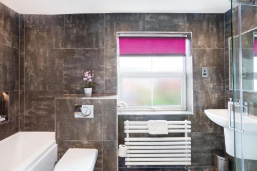 哈罗盖特The Harrogate Penthouse的浴室配有卫生间、浴缸和水槽。