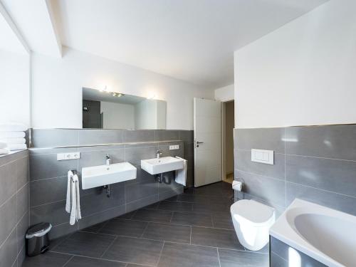 加尔米施-帕滕基兴GardenLodge的浴室设有2个水槽、卫生间和镜子。