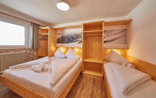 萨尔巴赫Ski & Bike Appartements Forsthaus的木墙客房的两张床