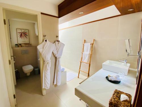 达喀尔BOMA LifeStyle Hotel的浴室设有白色浴袍和水槽