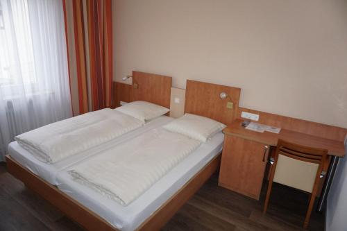 厄斯特里希-温克尔RUTHMANN-Rheinblick GARNI的一间卧室配有一张床和一张木桌