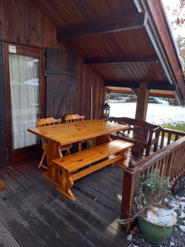 杜柏fraai chalet Barvaux的小屋门廊上的木桌和长椅