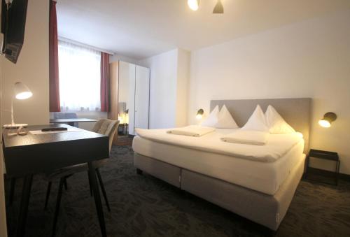 维也纳阿尔塔曼酒店的配有一张床和一张书桌的酒店客房