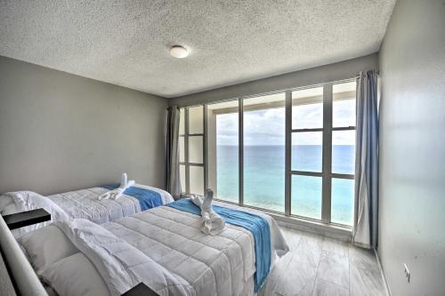林康Rincon Penthouse Steps to Private Beach Oasis!的一间卧室设有两张床和大窗户