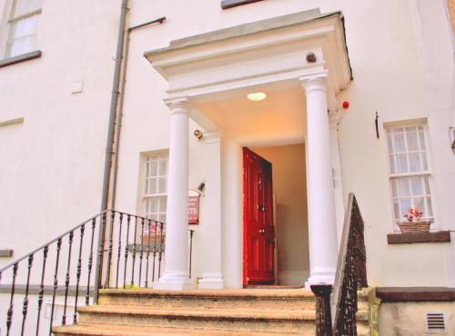 都柏林墨翰普顿联排别墅酒店的白色房子的红色门,有楼梯
