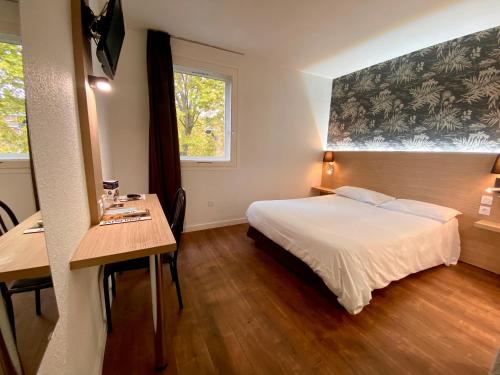 图卢兹波尔多酒店的一间卧室配有一张床、一张书桌和一个窗户。