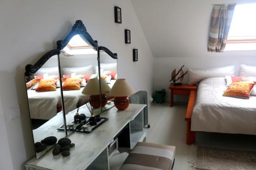 蓬塔杜帕戈Madeira Native Motion Apartment的一间带镜子、一张床和一张桌子的卧室