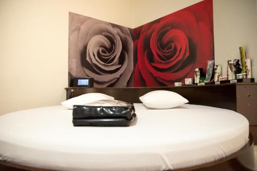 坎皮纳斯Prime Motel Campinas的黑色钱包坐在白色床上,画着一幅画