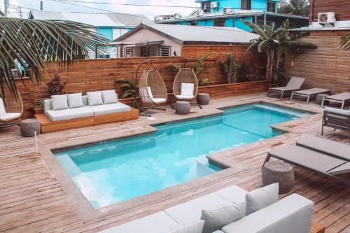 圣佩德罗沙洲海滨旅舍及餐厅的后院的游泳池,配有椅子和沙发