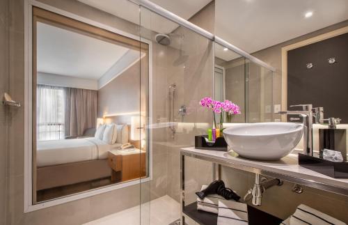 坎皮纳斯坎皮纳斯美利亚酒店的一间带水槽和玻璃淋浴的浴室