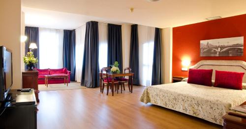 两姐妹Hotel TRH La Motilla的酒店客房带一张床、一张桌子和椅子