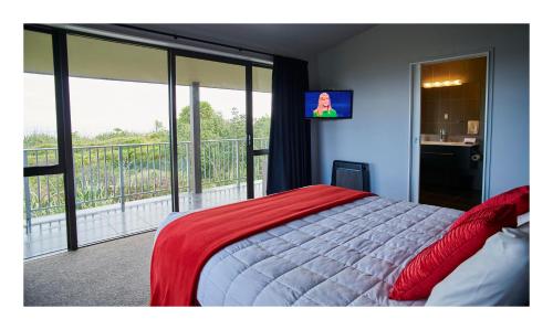 格雷默斯Luxury Seaview Apartments的一间卧室设有一张床,阳台配有电视。
