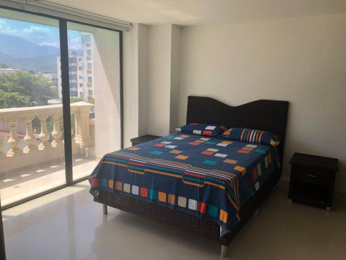 圣玛尔塔罗卡滨海公寓酒店的一间卧室设有一张床和一个大窗户