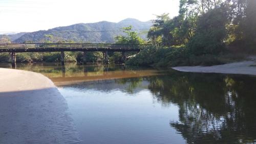 圣保罗CONDOMÍNIO ILHAS DO JUQUEHY的河上一座桥,在水中反射