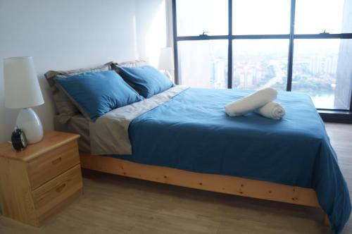 吉隆坡M City Lake View 1+1 Room的一间卧室配有一张带蓝色床单的床和床头柜。